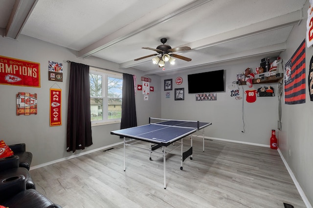 rec room with beam ceiling, a textured ceiling, hardwood / wood-style flooring, and ceiling fan