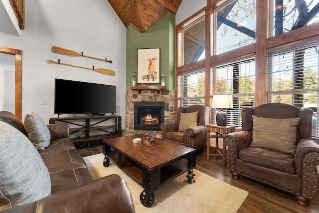 living room featuring a stone fireplace, hardwood / wood-style flooring, high vaulted ceiling, and wooden ceiling