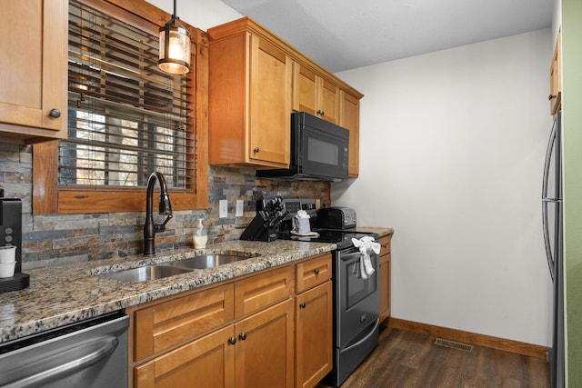 kitchen with black appliances, dark wood-type flooring, stone countertops, pendant lighting, and sink