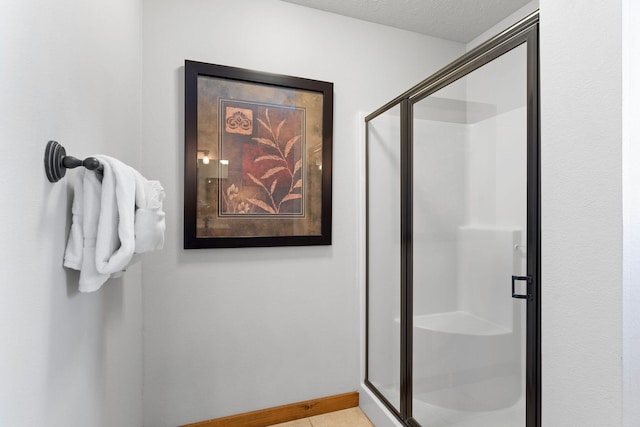 bathroom with a textured ceiling and an enclosed shower