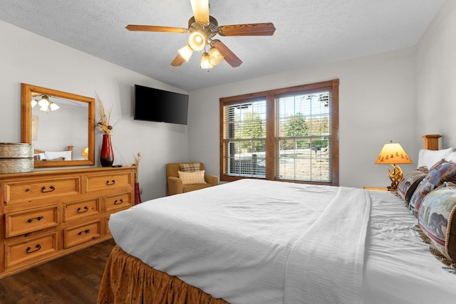 bedroom with dark hardwood / wood-style flooring, lofted ceiling, a textured ceiling, and ceiling fan