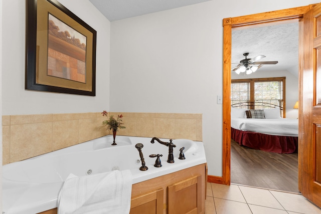 bathroom with a bathing tub, a textured ceiling, tile patterned floors, and ceiling fan