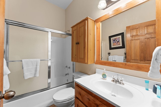 full bathroom featuring vanity, combined bath / shower with glass door, and toilet