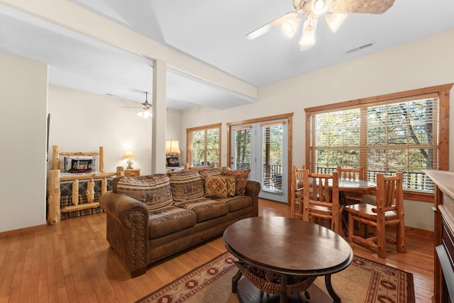 living room with ceiling fan, plenty of natural light, and light wood-type flooring