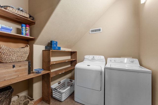 clothes washing area with light tile patterned flooring and washing machine and clothes dryer