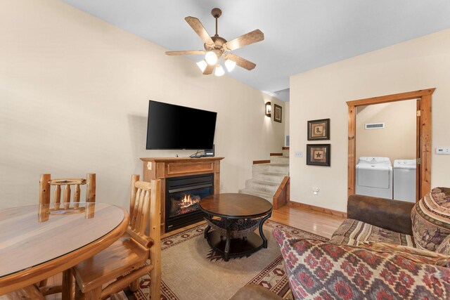 24 Baldknobber Dr Unit 18, Branson West, MO 65737 - living area featuring washing machine and dryer, stairs, wood finished floors, a ceiling fan, and a glass covered fireplace