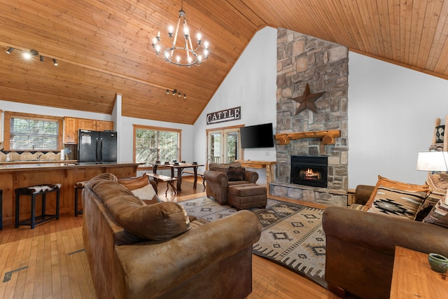 living room featuring high vaulted ceiling, wooden ceiling, light wood-type flooring, and a stone fireplace