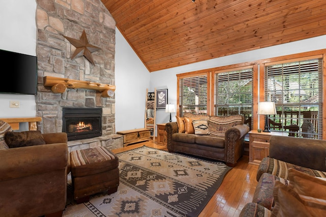 living room featuring wood ceiling, high vaulted ceiling, light wood-type flooring, and a fireplace