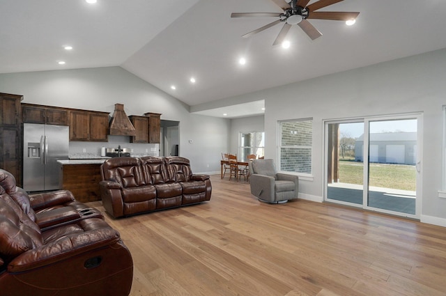 living room featuring light hardwood / wood-style floors, high vaulted ceiling, and ceiling fan