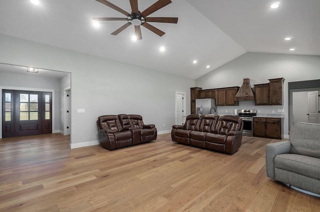 living room with light hardwood / wood-style floors, high vaulted ceiling, and ceiling fan