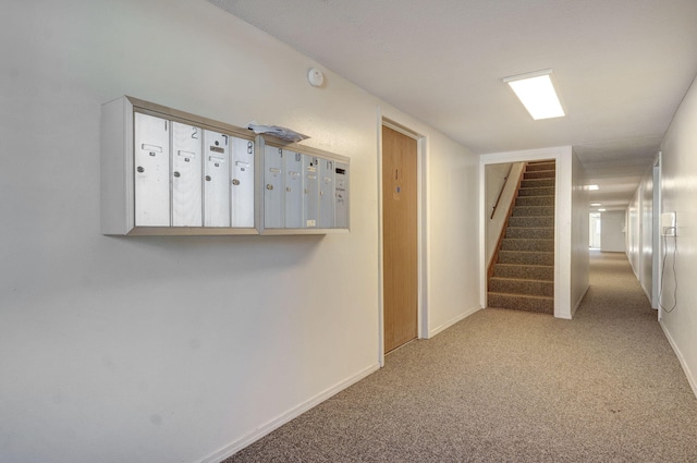 hall with a mail area and light colored carpet