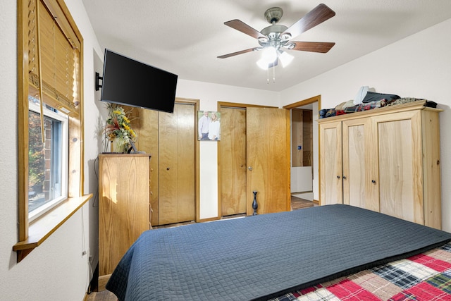 bedroom with multiple closets and ceiling fan