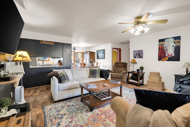 living room featuring hardwood / wood-style floors, a textured ceiling, and ceiling fan