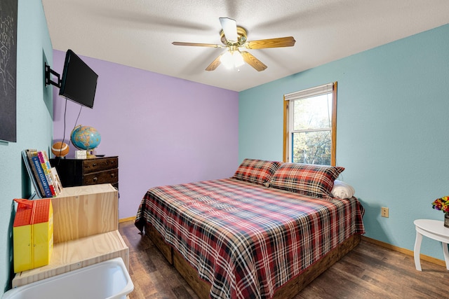 bedroom featuring dark wood-type flooring, a textured ceiling, and ceiling fan