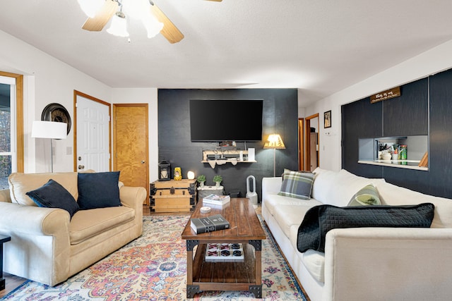 living room featuring a textured ceiling, light hardwood / wood-style floors, and ceiling fan