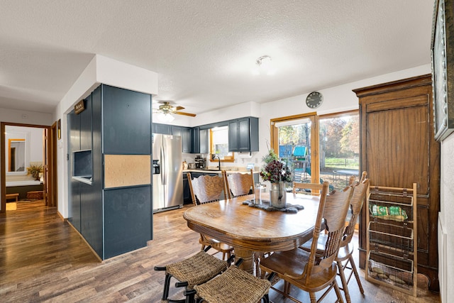 dining space featuring a textured ceiling, hardwood / wood-style flooring, and ceiling fan