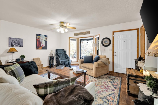 living room with ceiling fan, a textured ceiling, and dark hardwood / wood-style flooring