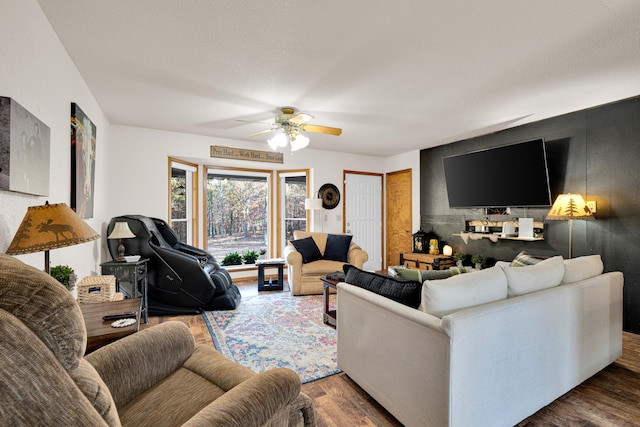 living room featuring dark wood-type flooring and ceiling fan