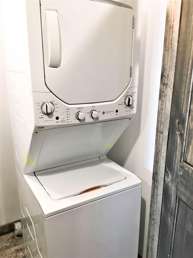 washroom featuring stacked washer and clothes dryer