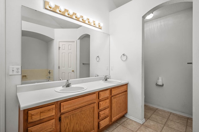 bathroom featuring vanity, a bath, and tile patterned floors