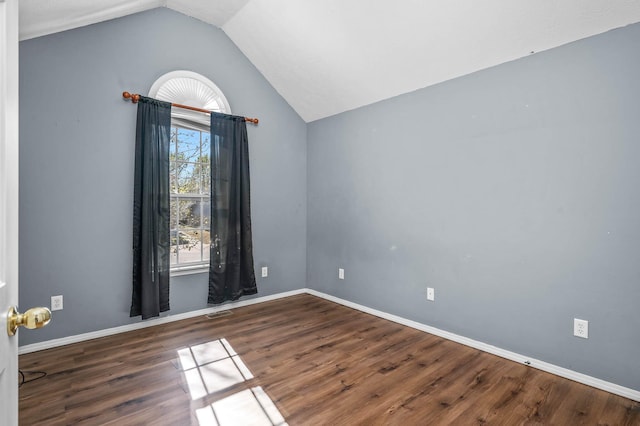 unfurnished room with vaulted ceiling and dark hardwood / wood-style flooring