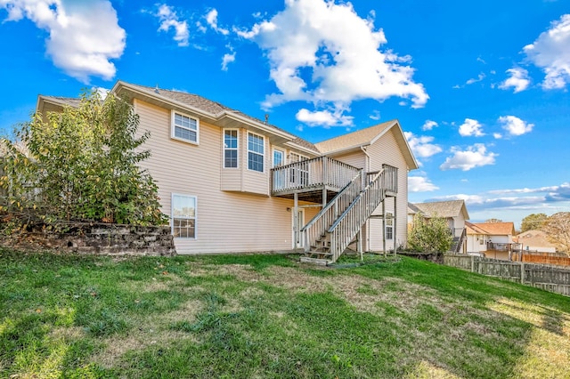 rear view of property with a wooden deck and a lawn