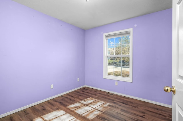 unfurnished room with dark hardwood / wood-style flooring