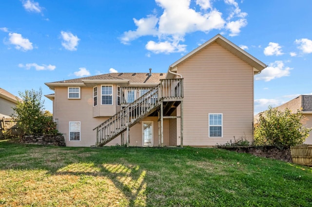 rear view of house with a wooden deck and a lawn