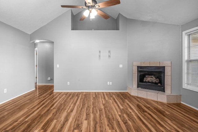 unfurnished living room featuring ceiling fan, high vaulted ceiling, wood-type flooring, and a fireplace