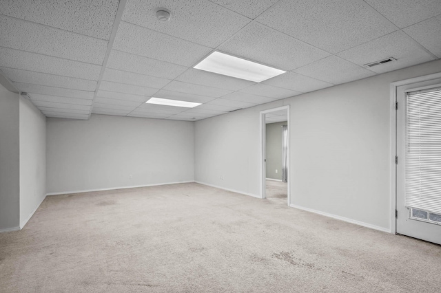 unfurnished room with carpet flooring and a drop ceiling