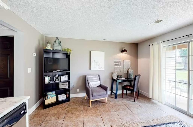 sitting room with a textured ceiling and light tile patterned floors