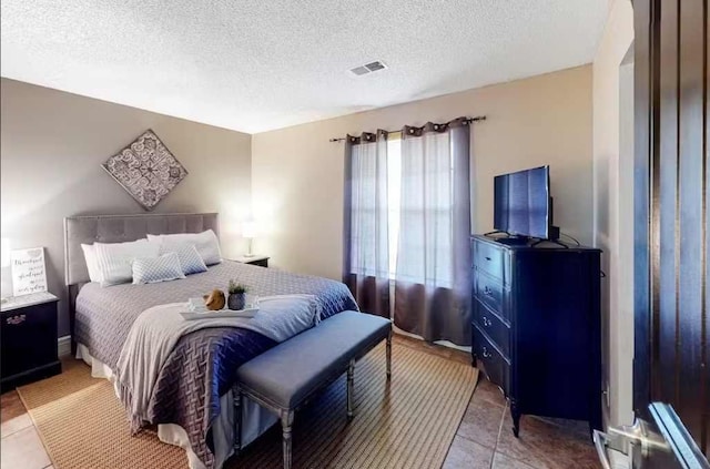 tiled bedroom with a textured ceiling