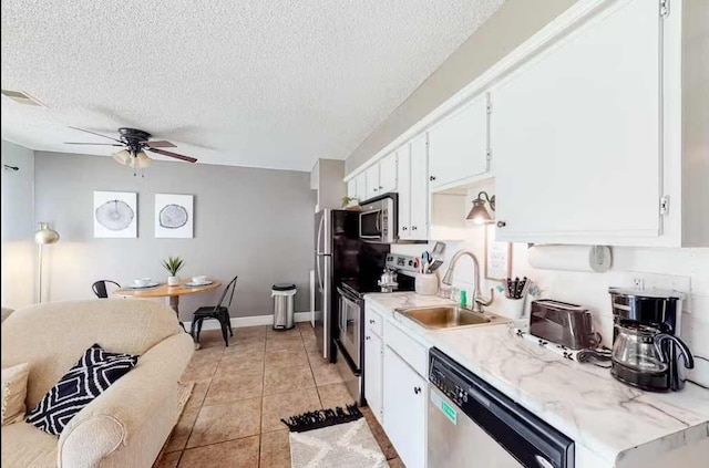 kitchen featuring white cabinets, stainless steel appliances, sink, and light tile patterned floors