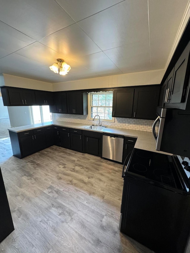 kitchen featuring dishwasher, sink, electric range, light hardwood / wood-style floors, and tasteful backsplash