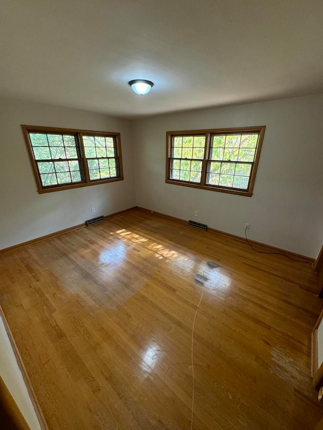 unfurnished room featuring a wealth of natural light and hardwood / wood-style flooring