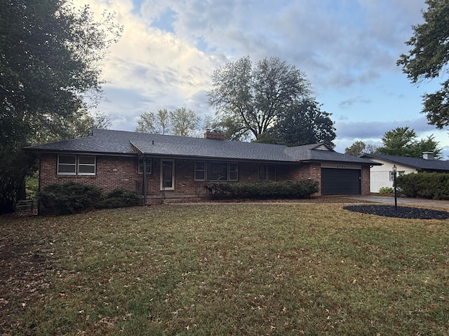 single story home featuring a front lawn and a garage