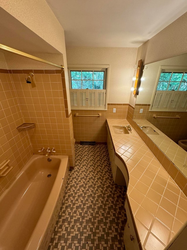 bathroom featuring vanity, tile walls, and tiled shower / bath