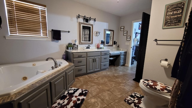 bathroom featuring toilet, a tub to relax in, and vanity