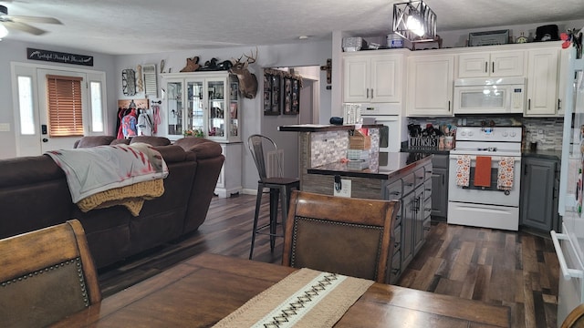 kitchen featuring white appliances, tasteful backsplash, white cabinetry, gray cabinets, and dark hardwood / wood-style floors