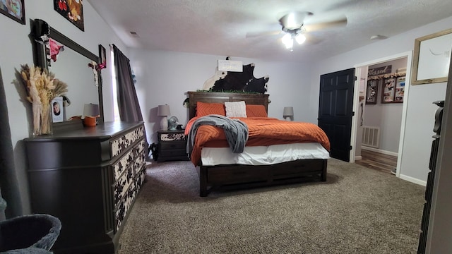 bedroom featuring dark colored carpet, a textured ceiling, and ceiling fan