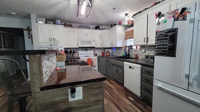 kitchen featuring decorative backsplash, white cabinets, dark hardwood / wood-style floors, sink, and white appliances