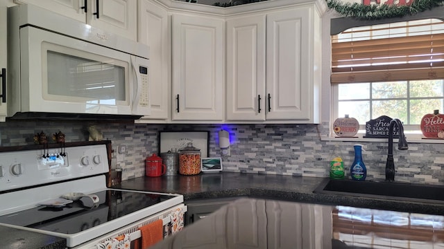 kitchen featuring white cabinets, tasteful backsplash, sink, and white appliances