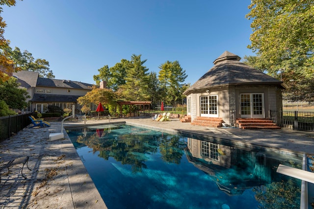 view of swimming pool with a patio and a diving board