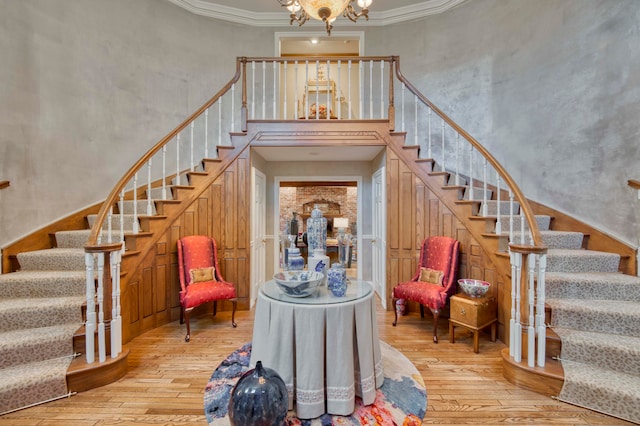 staircase featuring an inviting chandelier, hardwood / wood-style floors, and ornamental molding