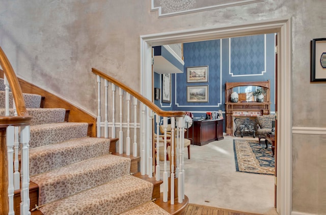 stairs featuring a towering ceiling and hardwood / wood-style flooring