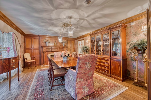 dining space with light wood-type flooring, a chandelier, and crown molding