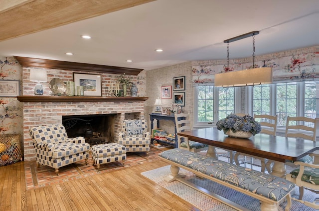 dining room with a brick fireplace and hardwood / wood-style floors