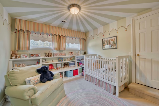 bedroom featuring light carpet and a nursery area