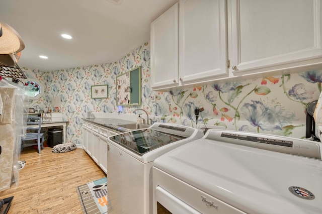 washroom with cabinets, sink, light wood-type flooring, and washing machine and clothes dryer