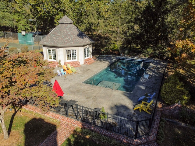 view of swimming pool featuring an outbuilding and a patio